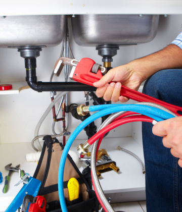 Plumber Working Under Sinks